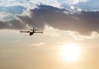 Gün batımında bir uçağın silueti.