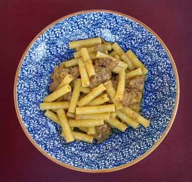 Geleneksel Ziti alla Genovese makarnası yavaş pişmiş soğan ve biftek ragu ile Castelfiorentino, Tuscany 'de servis edilir ve zengin bir İtalyan mutfak deneyimi sunar.
