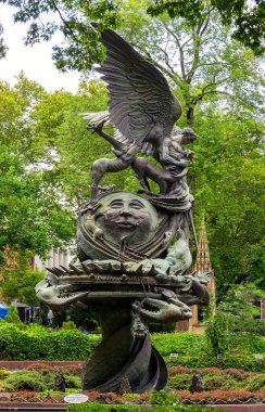 New York 'taki Aziz John Katedrali' nin dramatik bronz heykeli, yemyeşil ve gotik elementlerin ortasında bir ejderhayı alt eden melek figürüne ev sahipliği yapıyor.