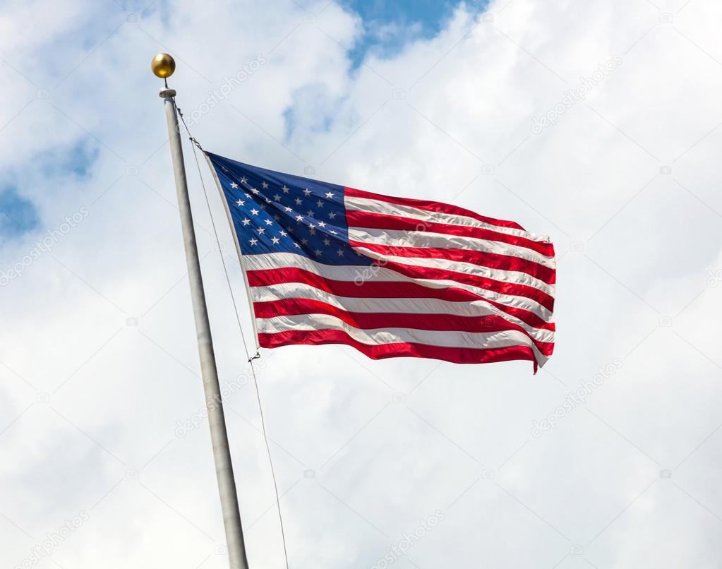 USA flag on blue sky with clouds