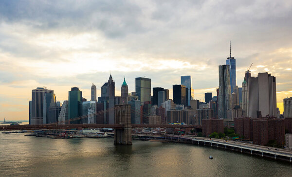 Manhattan skyline and Brooklyn bridge at sunset photographed by manhattan Bridge.