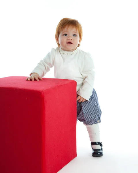 Criança bonito brincando com um cubo vermelho — Fotografia de Stock