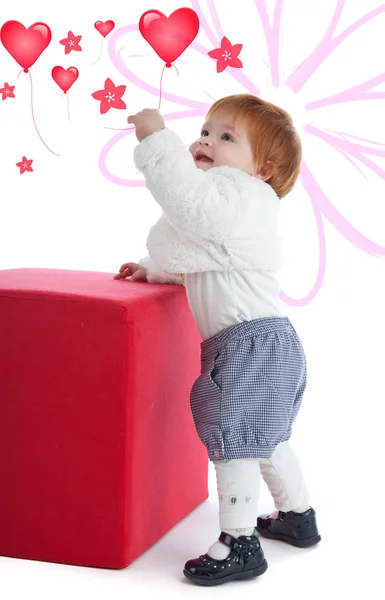 Söta barn leker med en röd kub — Stockfoto