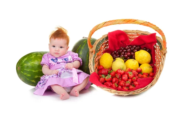 Niedliches Baby sitzt neben Obstkorb — Stockfoto