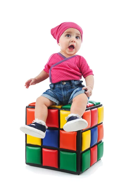 Lindo niño hembra sentado en un cubo de colores — Foto de Stock