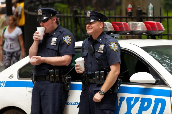 Two police officers while drinking a cup of coffee in NYC. — Stock Photo, Image