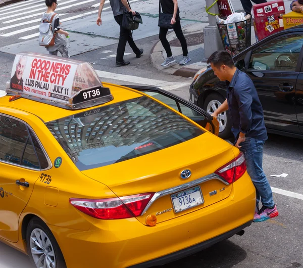 Asian tourist takes the yellow cab in Manhattan, NYC. — стокове фото