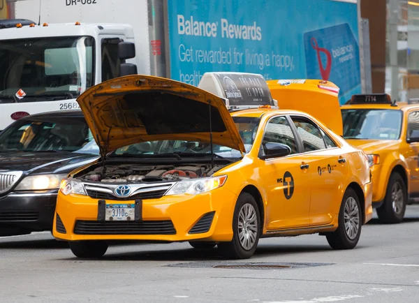Yellow cab stopped in traffic due to the broken engine — Stock Photo, Image