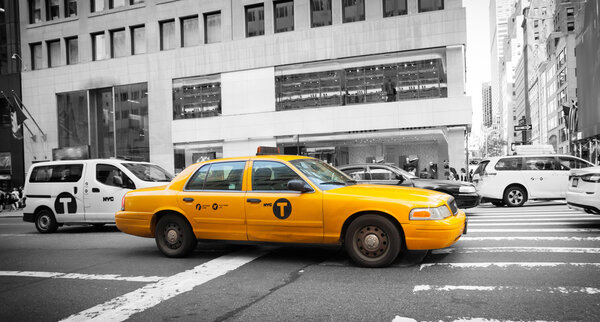NEW YORK CITY, NY, USA - JULY 07, 2015: Classic street view with yellow cabs. Yellow cab in Manhattan with black and white background. The taxicabs of New York City are widely recognized icons of the city.