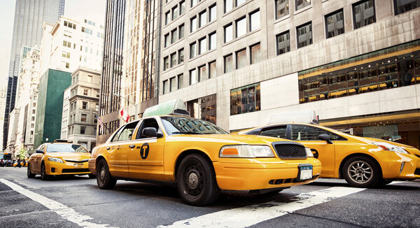NEW YORK CITY, NY, USA - JULY 07, 2015: Classic street view with yellow cabs. Yellow cabs in Manhattan, NYC. The taxicabs of New York City are widely recognized icons of the city.