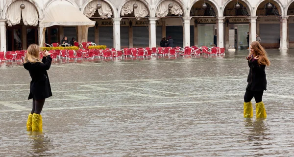 Toeristen in San Marco plein met hoog tij, Venetië, Italië. — Stockfoto