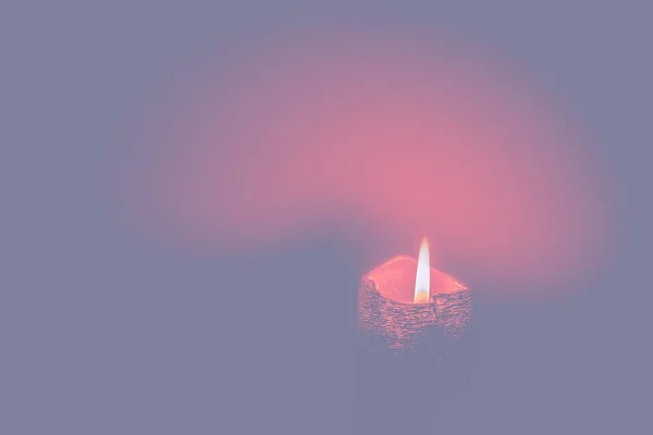 霧のパステルトーンの背景に燃える赤いキャンドル ピンクの環境でキャンドルライト 選択的焦点 — ストック写真