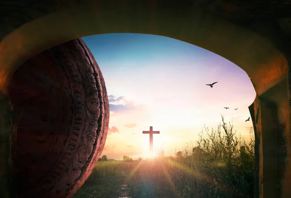 Easter concept: Tomb stone with holy cross and sunset sky background