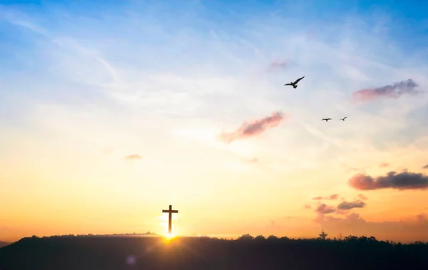 Religious cross concept: Silhouette cross on mountain at sunset background