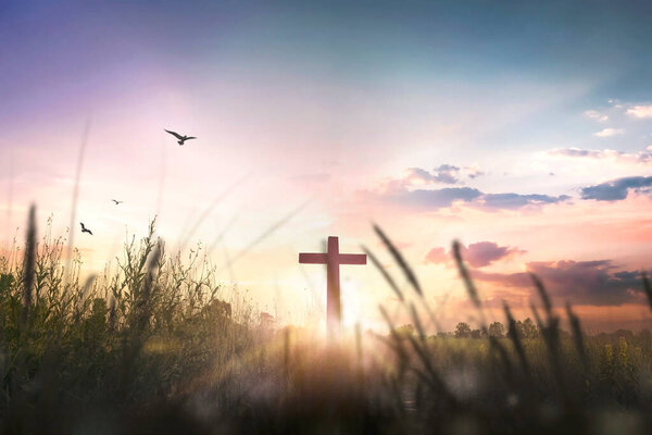 Religious cross concept: Silhouette cross on mountain at sunset background
