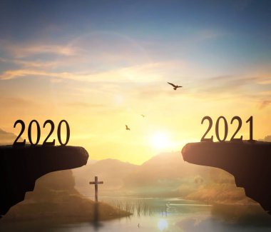 2021 konsepti: 2021 yılının silueti ve gün batımı arka planıyla dağları aşmak