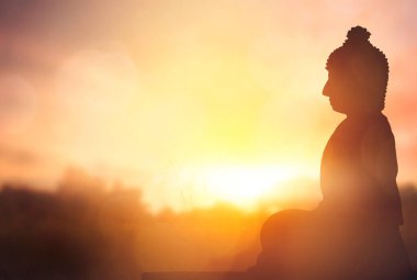 Vesak Günü konsepti: Altın günbatımı arka planında Siluet Buddha