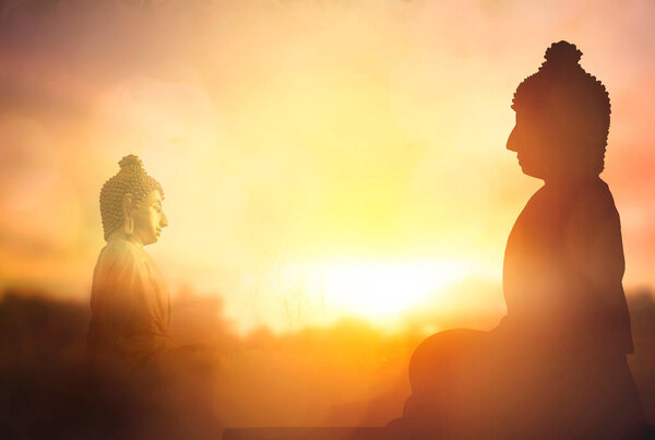 Vesak Day concept: Silhouette Buddha on golden sunset background
