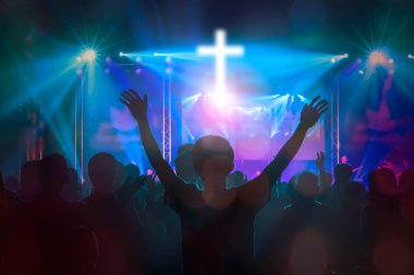 Hıristiyanlar arka planda ellerini kaldırıp dua ediyorlar.