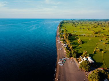 Aerial drone view of the beautiful black sandy beach view in Bali, Indonesia