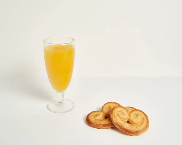 Beyaz arka planda portakal suyu olan Cookie Palmier