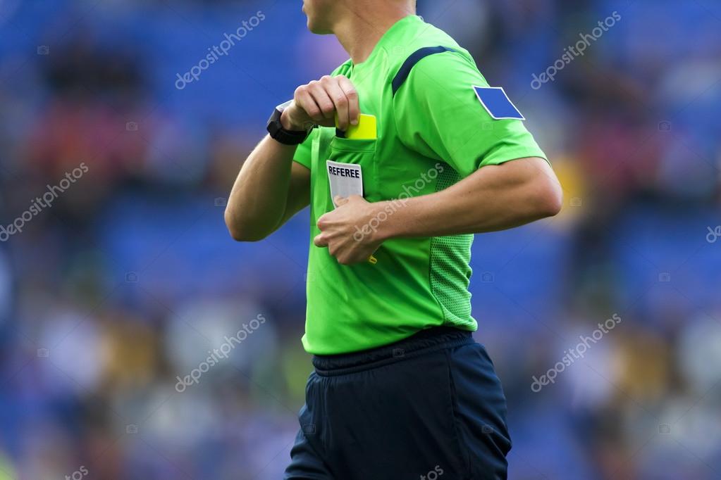 Download - Soccer referee to point out a yellow card to a player during a match - Stock Image
