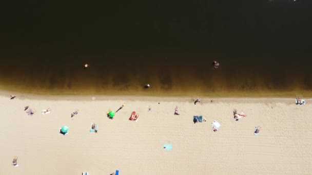 Drone shot of the bank of the river beach in the city - resting people on the river sandy beach — Stock Video