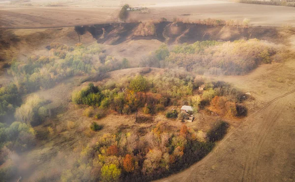 Casa abandonada entre os campos na encosta no outono no nevoeiro — Fotografia de Stock