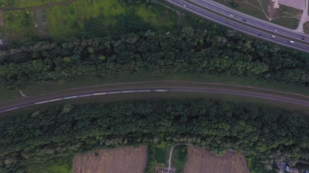Zoom-Aufnahme eines Zuges mit vielen Waggons, der auf der Bahn fährt - Ansicht von oben. — Stockvideo