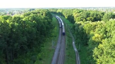 Vagonları olan iki trenin geri sürüşü - havadan takip eden çekim.