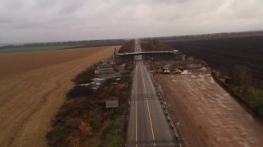 Yoldan geçen insansız hava aracı tamamlanmamış beton üstgeçit inşaatına doğru ilerliyor.