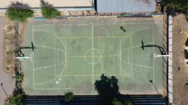 Basketbol sahasında bir adam topu ringe fırlattı ve ıskaladı.