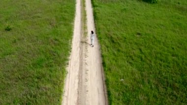 Yazın toprak yolda koşan Avrupalı Kadın, ağır çekim - iz sürme