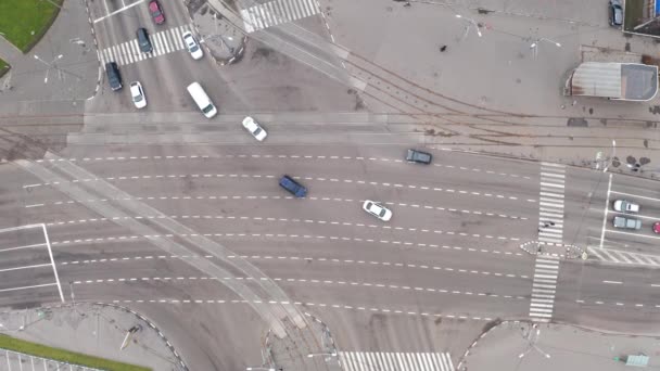 Un montón de coches que pasan por una gran intersección de una amplia calle en la ciudad - vista superior drone disparo. — Vídeo de stock