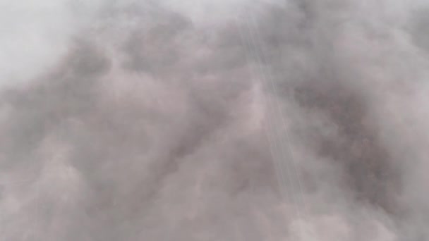 Vuelo en espiral cinematográfico sobre la autopista en una densa niebla a gran altitud - con coche blanco en movimiento — Vídeos de Stock