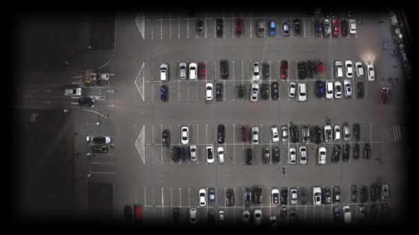 Pohyb aut na parkovišti u supermarketu v noci - nad hlavou drone shot. — Stock video