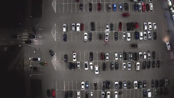 O movimento de carros no estacionamento perto do supermercado à noite - overhead drone shot. — Vídeo de Stock