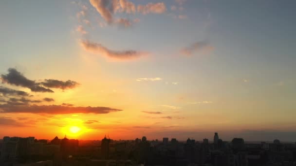 Paisaje urbano - horizonte con edificios de la ciudad durante la puesta de sol vívida con épicas nubes de color rosa y naranja — Vídeos de Stock