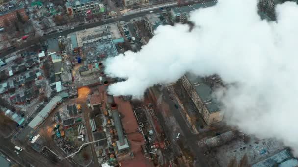 Špinavý kouř se škodlivými látkami pochází z potrubí továrny ve městě - letecký pohled — Stock video