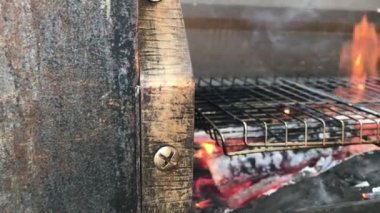 Et pişirmek için büyük bir ızgarada şenlik ateşi yanıyor.