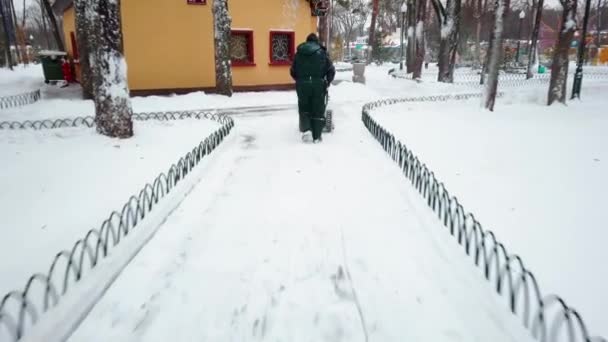 Kharkiv, Ucrânia, janeiro de 2021: Trabalhador de serviços públicos limpa o caminho da neve — Vídeo de Stock