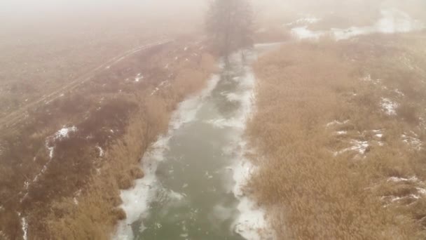 Ontdooien op de rivier - mist van smeltend ijs en sneeuw over de bedding van een riviertje - Vliegen Over shot — Stockvideo