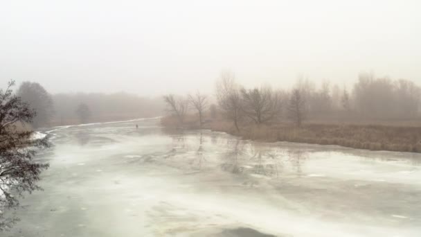 Rybáři na povrchu ledu na tající řece během tání - dron přeletět nad výstřelem — Stock video