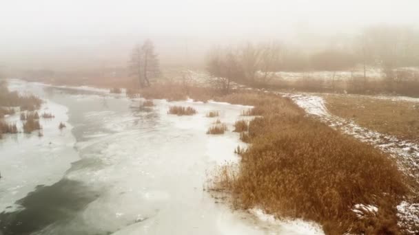 Tauwetter auf dem Fluss - Nebel aus schmelzendem Eis und Schnee über dem Bett eines kleinen Flusses - Drohnenschuss in den Orbit — Stockvideo