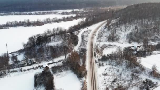 Çevredeki karla kaplı bir köyden geçen uzun bir yol.. — Stok video