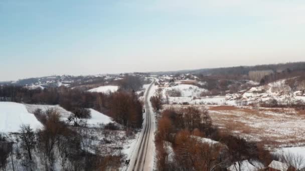 Etrafı karla kaplı bir köyde ufukta uzun bir yol var.. — Stok video