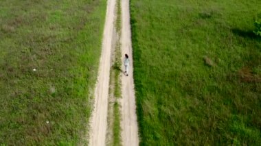 Genç sporcu kadın toprak yolda koşuyor. Ağır çekim.