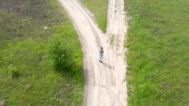 Genç kız toprak yolda koşmadan önce ısınıyor.