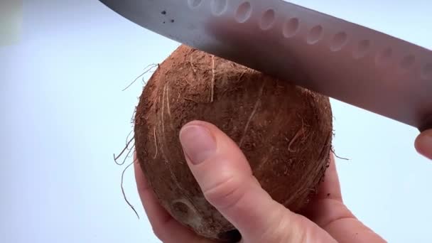 Uma mulher descasca a carne de um coco com um descascador de vegetais. — Vídeo de Stock