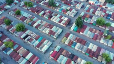 Unutulmuş ve kayıp eşyalar deposunda bir sürü renkli konteynır ve garaj var.